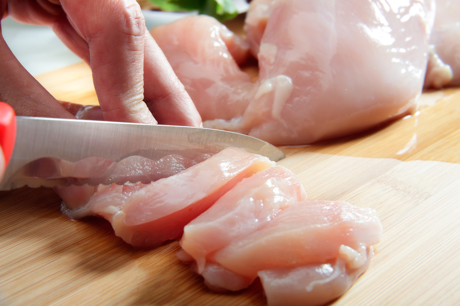 Professional butcher cutting fresh chicken
